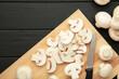 Fresh white champignon mushrooms on cutting board. Space for text