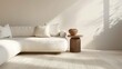 a minimalistic white sofa with a side table and light-colored carpet in a naturally lit room