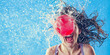 Woman getting hit in the face by a red water balloon, wide banner, copyspace, blue background