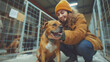 Smiling woman in yellow beanie bonding with brown dog at shelter, happiness in rescue. Affectionate interaction highlights joy of animal adoption