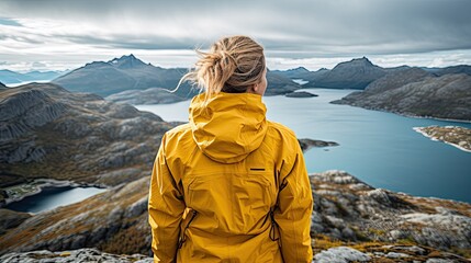 Wall Mural - woman in yellow jacket standing on the mountain