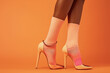 chic pastel peach socks paired with elegant cream high heels on orange backdrop