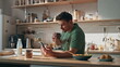 Drinking businessman surfing cellphone kitchen closeup. Guy enjoying breakfast