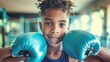 Smiling African American boy with blue boxing gloves. Cheerful young boxer in gym attire ready to train. Child boxer. Concept of healthy lifestyle, fitness training, childhood activity