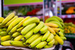 A lot of bananas on the counter against background of other fruits in outdoor grocery market
