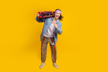 Sticker - Full body portrait of cool young man direct finger boombox empty space wear denim shirt isolated on yellow color background