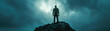 Silhouette of a man standing atop a rugged peak against a dramatic and tumultuous sky.