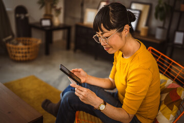 Japanese woman use credit card mobile phone online shopping at home