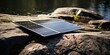 Portable solar panels lie on stone shore of lake, concept of Renewable energy