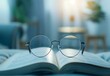 A pair of glasses resting on an open book, symbolizing the connection between reading and vision health