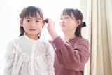 Fototapeta  - 女の子の髪をセットするお母さん