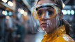 A professional woman in a yellow jacket and clear safety goggles with an integrated face shield.