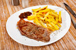 Delicious grilled beef with french fries served at the plate