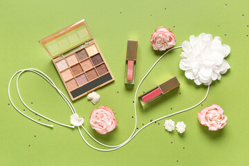 Wall Mural - Eyeshadows palette with lip glosses, accessories and roses on green background