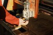 A man's hand is changing the milling cutter on a CNC machine for cutting wood in a carpentry workshop, wood cutting, equipment repair.