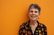 © Igor - Portrait of a happy senior woman smiling at the camera over yellow background