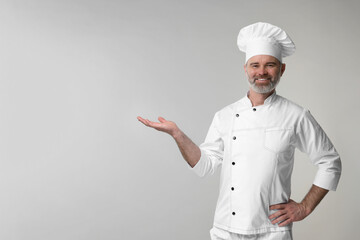 Poster - Happy chef in uniform posing on grey background, space for text