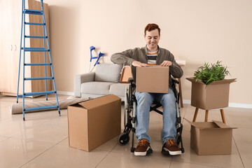 Wall Mural - Young man in wheelchair packing box during repair at home