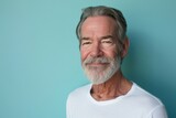 Fototapeta  - Portrait of a senior man with grey beard against a blue background