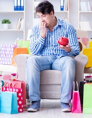 Wall Mural - The young man after excessive shopping at home