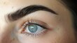 Thin sculpted brows are raised in a skeptical curve suggesting doubt or suion. .