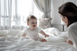 Cute baby laughing crawling on top of a bed, in daylight