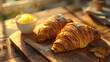 Two croissants and butter on a wood board, a Viennoiserie staple food
