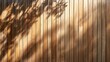 A tree casts a shadow on a wooden fence in the background. Wallpaper.