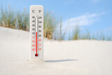 Fototapeta  - Hot summer day. Celsius and fahrenheit scale thermometer in the sand. Ambient temperature plus 15 degrees