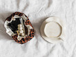 Cappuccino cup, cosmetic bag with leopard print on a light background, top view