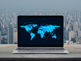 Fototapeta Panele - Connection line with global world map on laptop computer monitor screen on wooden table over city tower and skyscraper, Business communication online concept, Elements of this image furnished by NASA
