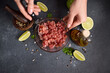 Woman mixing Sliced and chopped tuna fillet and spices in glass bowl cooking traditional tartare