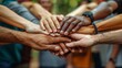 Vibrant image capturing a diverse group of young adults stacking their hands together in a gesture of unity and teamwork, set against an outdoor background.
