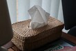 Straw box for napkins laid on a table
