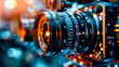 Close-up of a professional camera lens with focus rings, amidst blurred photographic equipment in the background.