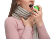 Woman using throat spray on white background, closeup