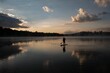 © Wirestock - Beautiful view of a man on a puddle board on a sunset scene background