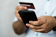 A businessman using credit card to pay online with smartphone, buying online concept
