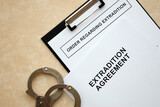 Fototapeta  - Extradition Agreement and Order Regarding Extradition with handcuffs on table close up