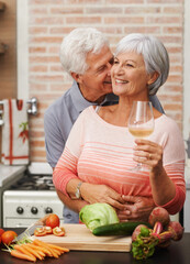 Wall Mural - Senior couple, wine and love in kitchen for happiness, health and retirement in apartment for commitment. Elderly man, woman and cooking together on vacation for lunch, anniversary and gratitude.