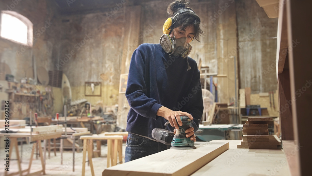 Woman carpenter sanding wood block. Feminist girl process timber bar. Male carpentry work skill. Female joiner woodwork. Feminism worker. Person use sander tool. Diy master class workshop. Job project
