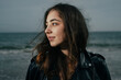 Portrait of young woman in leather jacket at the sea