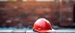 Red hard hat on brick wall