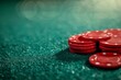 Red poker chips stacked on green poker table baize