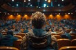 A person from the back, watching a stage in an auditorium reflecting focus and anticipation