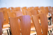 chaises en bois rangées dans une salle de concert, de conférence, de spectacle ou de cours