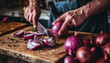 Hands cutting red onions.