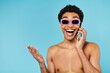 happy good looking african american man in swimming trunks with stylish sunglasses talking by phone