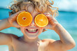 © Fernando Cortés - Joyful kid playing with oranges on the beach, summer holiday vibes captured in a single shot.