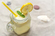 Fresh lemon drink with straw. Jar glass of lemonade on sand beach.
